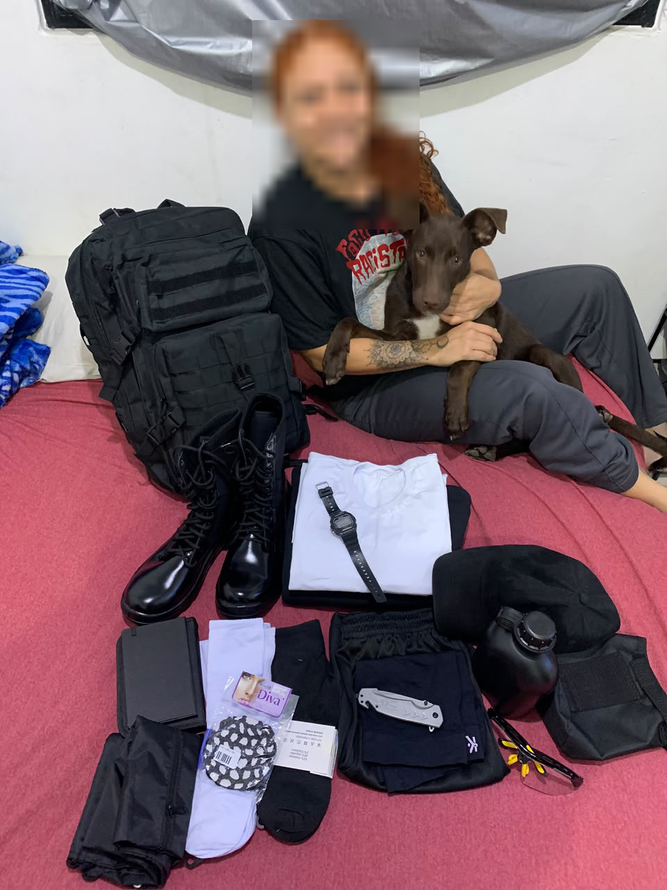 Thyciane ao lado de equipamentos e de um cachorro, com o rosto pixelado